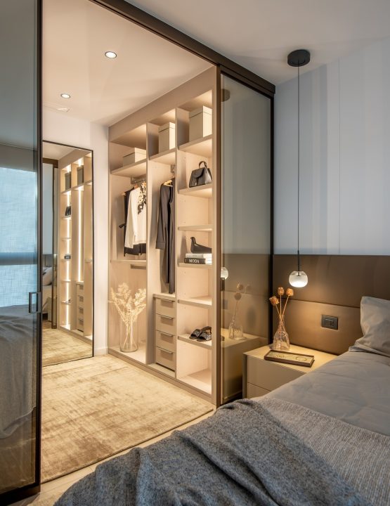 Skjutdörr från Albed i tonat glas som avskiljer en elegant garderob från sovrummet och skapar en luftig men privat lösning